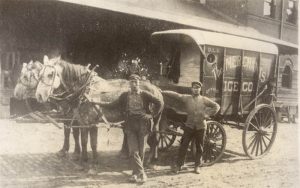 Man standing in front of horse and wagon